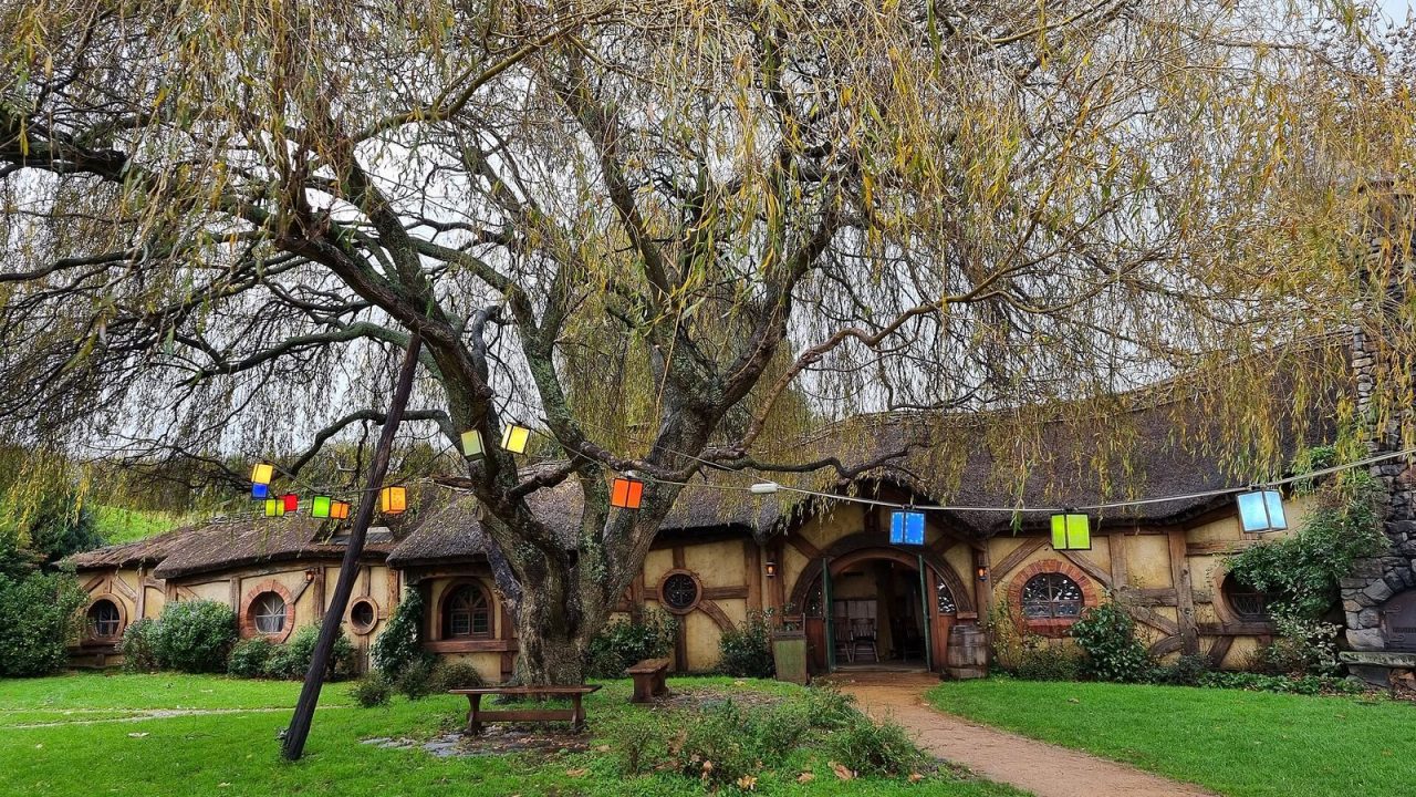 Green hillside with round hobbit-hole doors at the Hobbiton film set in Matamata, New Zealand