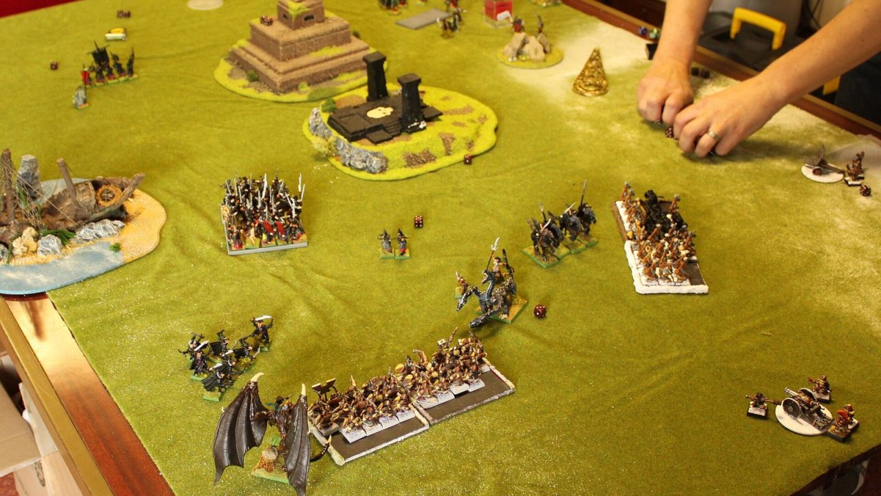Tabletop game of Warhammer Fantasy Battle with Dark Elf and Dwarf miniatures on terrain